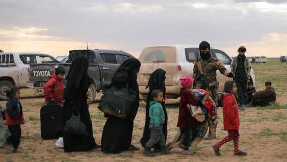 Women walk with children near the village of Baghouz in the Deir Az Zor province [File: Rodi Said/Reuters]