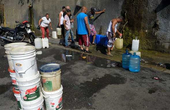 Colas para llevarse agua potable en la ladera de El Ávila, en Caracas