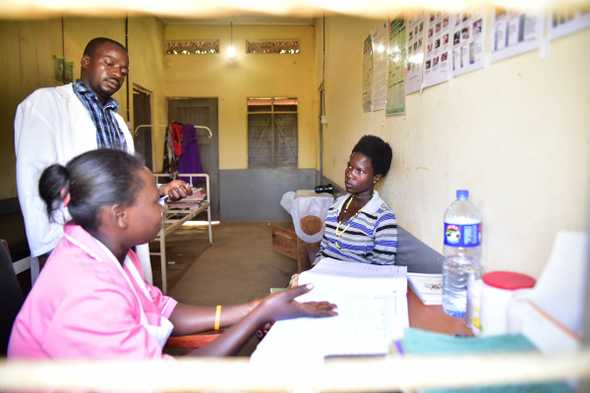 Sandra Naigaga (R) receives antenatal advice from Joshua Musomba and midwife Juliet Namuswa. Every day 15 women die in Uganda from childbirth and pregnancy-related issues. [Nicholas Bamulanzeki/Al Jazeera]